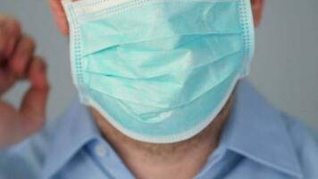 pandemia protezione di il covid-19 coronavirus. barbuto caucasico uomo mette su un' protettivo medico maschera. virus protezione. video