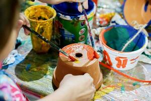 Asian little girl study and learning paint on flower pot in the art classroom of her school. photo