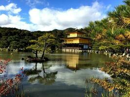 Golden temple hall at Kinkakuji Temple under bright blue sky photo