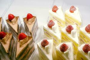 Closeup and crop vanilla cream cake slice with fresh strawberry for sale in cafe. photo