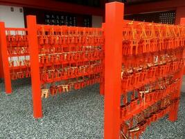 Closeup Ema in red torii at Fushimi Inari Shrine in Kyoto, Japan. Ema are small wooden plaques used for wishes by shinto believers. photo