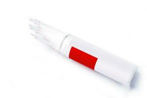 Closeup of medical capillary glass tube emerged from container on white background., Designed for both safe blood collection as well as accurate micro-hematocrit determinations Precision. photo