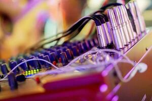 Closeup sound jacks and knobs button of sound control in colorful lights party on blurry background. photo