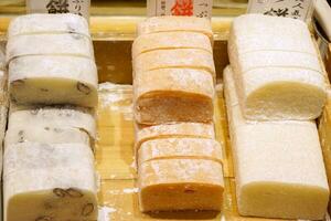 Japanese dessert for sale in wooden box at Kuromon market. Mochi is a Japanese dessert are so popular in asian tourists because It has a sweet taste and have good smell. photo