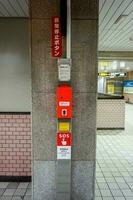 Osaka, Japan, 2018 - Closeup SOS switch and button of emergency stop train on Osaka train station's pillars. photo