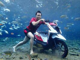 Klaten, Umbul ponggok, Indonesia, July 22, 2022,  a man taking a photo under clear water