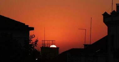 golden Stunde Sonnenuntergang hinter ein Gebäude mit rot Himmel im Nazaré, Portugal - - schließen oben video