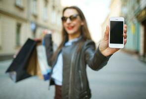 Online shopping concept -l woman with shopping bags and smart phone in the hands photo