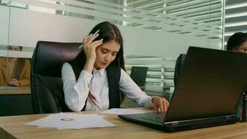 Businesswoman is overwhelmed and feels stressed out at workplace. video