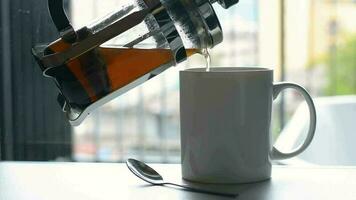 derramando fresco café dentro para branco café copa.por a janela. beber fresco café dentro a manhã às lar. video