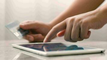 Female hands of cardholder holding credit card making e bank online payment. Woman  paying for purchase in web store using digital taplet.  Close up view video