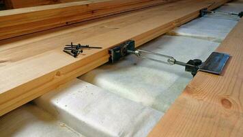 Floor works,wooden house construction. Warming, laying, fitting and fixing floor planks photo