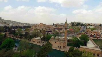 aéreo Visão do velho cidade com pedra arquitetura, histórico mesquita com minarete e lago, sanliurfa, peru, halil-ur-rahman mesquita video