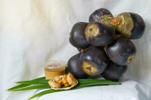 Toddy palm, pulp ,fragrant pandan leaves and a jar of Palmyra palm sugar on white cloth. suitable for making many desserts such as Toddy palm cake, Toddy Palm Fruit in Syrup. photo