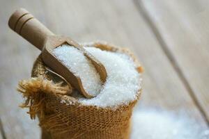 white sugar for food and sweets dessert candy heap of sweet sugar crystalline granulated, Sugar on sack and wooden background photo