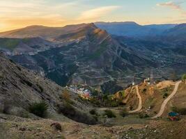 auténtico ciudad con serpentina suciedad la carretera en el roca. Clásico daguestán montaña pueblo de gunib en amanecer. Rusia. foto