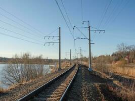 Empty railway track, single rail. Railway track turns and twists between out of focus hills background. Empty rounding and turning single track of railways. photo