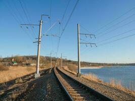 Empty railway track, single rail. Railway track turns and twists between out of focus hills background. Empty rounding and turning single track of railways. photo