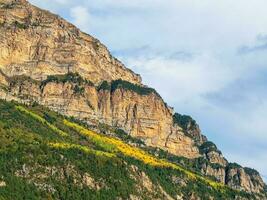 Beautiful mountain landscape with red rounded rocks. Big rock formation, different rock formations and soil layers. Distant mountain plateau. North Ossetia. photo