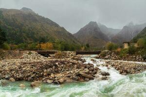 Panoramic view of amazing mountain stormy Khares River in North Ossetia. Awesome highland scenery with beautiful glacial streams among rainy hills and rocks. Caucasus Mountains. photo