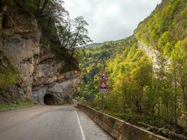 montaña carretera, a el Entrada a el túnel cortar dentro el roca. hermosa calle en un rocoso túnel. Cáucaso montañas. digora garganta, norte osetia-alania república. foto