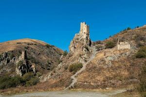 soleado tarde en el Cáucaso montañas. medieval torre complejo vovnushki, uno de el auténtico medieval tipo castillo torre pueblos, situado en el extremidad de el montaña rango en ingushetia foto