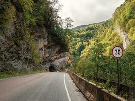 montaña carretera, a el Entrada a el túnel cortar dentro el roca. hermosa calle en un rocoso túnel. Cáucaso montañas. digora garganta, norte osetia-alania república. foto