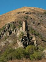 soleado tarde en el Cáucaso montañas. medieval torre complejo vovnushki, uno de el auténtico medieval tipo castillo torre pueblos, situado en el extremidad de el montaña rango en ingushetia foto