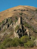 Sunny afternoon in the Caucasus mountains. Medieval tower complex Vovnushki, one of the authentic medieval castle-type tower villages, located on the extremity of the mountain range in Ingushetia photo