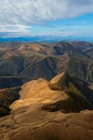 amanecer ver de bermamyt meseta rocas montañas en el borde de un acantilado en el distancia en soleado Mañana. atmosférico paisaje con siluetas de montañas. karachay-cherkesia, Cáucaso, Rusia. foto