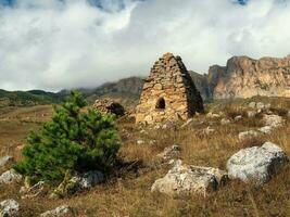 antiguo Roca tumba, un cripta en el parte superior de un montaña. antiguo osetio familia cripta en el brumoso montañas. Rusia. foto