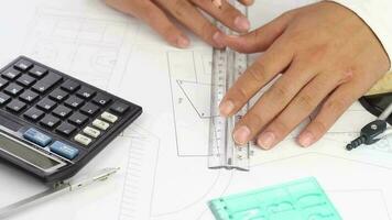 Hands of archtitect man calculating and design making model building on desk, architectural drawings, selective focus video