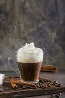 Mug of Viennese coffee with whipped cream and cinnamon on the table vertical view photo