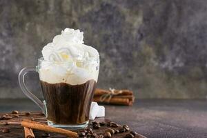 Mug of Viennese coffee with whipped cream and cinnamon on the table photo