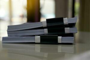 A stack of papers on the table waiting to be reviewed by the supervisor and confirmed for correctness so that the secretary can revise. Soft and selective focus. photo