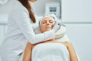 Woman having permanent eyebrows cosmetology treatment in salon photo