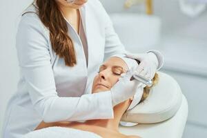 Woman having permanent eyebrows cosmetology treatment in salon photo