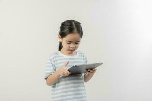 smiling little girl stiiting and holding a tablet photo