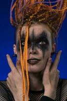 Fine art portrait of beauty young woman with dreadlocks hairstyle and horror black stage make-up photo