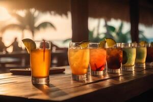 Wooden table and glasses with cocktails in the eground and soft focus summer beach and a bar in the blurred background tropical resort banner as a tropical holiday concept. photo