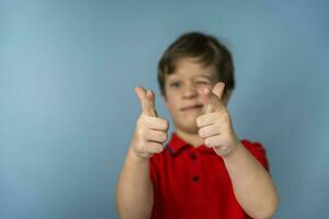 boy cheerfully shoots his fingers folded into the shape of a pistol. the boy put his fingers in the shape of a gun photo