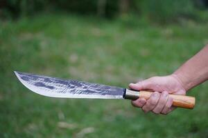 de cerca mano sostiene Clásico cuchillo . concepto ,herramienta o equipo en cocina, utilizar para el cortar, corte cuando Cocinando o otro propósitos como arma, caza. cuchillos en local cocina foto