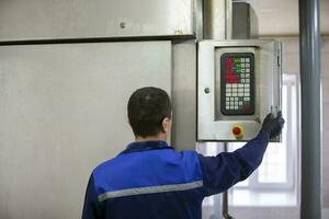 September 18, 2020. Belarus, Gamil. Fish factory.A worker turns on an industrial oven. photo