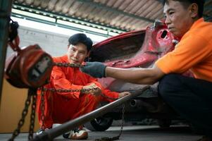 To return the automobile body to its former shape, an auto repair mechanic uses a machine to pull the car body caused by a heavy collision until it is deformed. photo