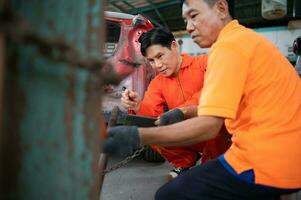 To return the automobile body to its former shape, an auto repair mechanic uses a machine to pull the car body caused by a heavy collision until it is deformed. photo