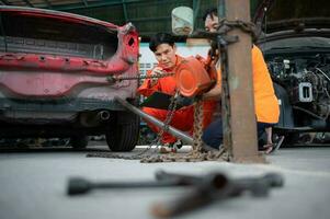 To return the automobile body to its former shape, an auto repair mechanic uses a machine to pull the car body caused by a heavy collision until it is deformed. photo
