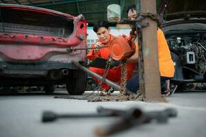 To return the automobile body to its former shape, an auto repair mechanic uses a machine to pull the car body caused by a heavy collision until it is deformed. photo