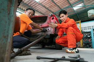 To return the automobile body to its former shape, an auto repair mechanic uses a machine to pull the car body caused by a heavy collision until it is deformed. photo