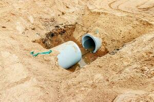 hormigón drenaje tubo en un construcción sitio .concreto tubo apilado aguas residuales agua sistema alineado en sitio foto