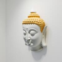 A white wall sculpture of a face with Gautama buddha head as mural for home decor etc. . photo